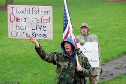 27855874-8275171-A_man_is_seen_holding_an_American_flag_with_a_sign_that_reads_I_-a-58_1588292...jpg